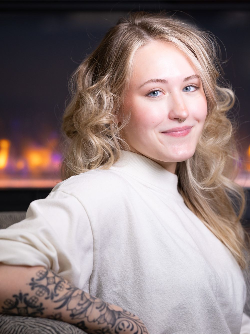 A series of photos showing a person with blonde wavy hair in a white sweater posing against a dark background.