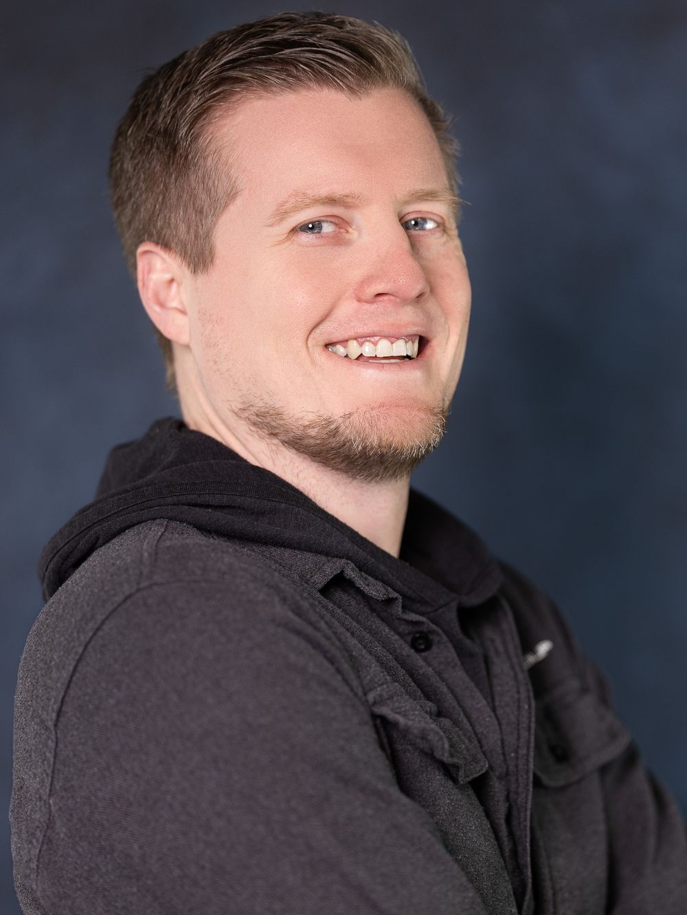 Professional headshot series showing different poses and expressions against a dark studio background.