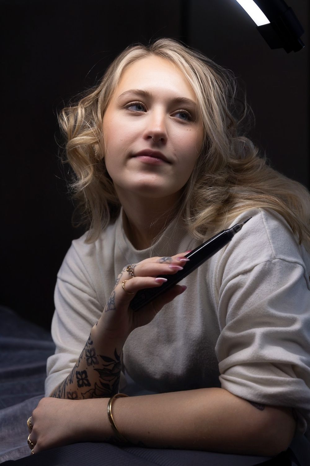 Artistic portrait series showing reclining figure in white against dark background with dramatic lighting.