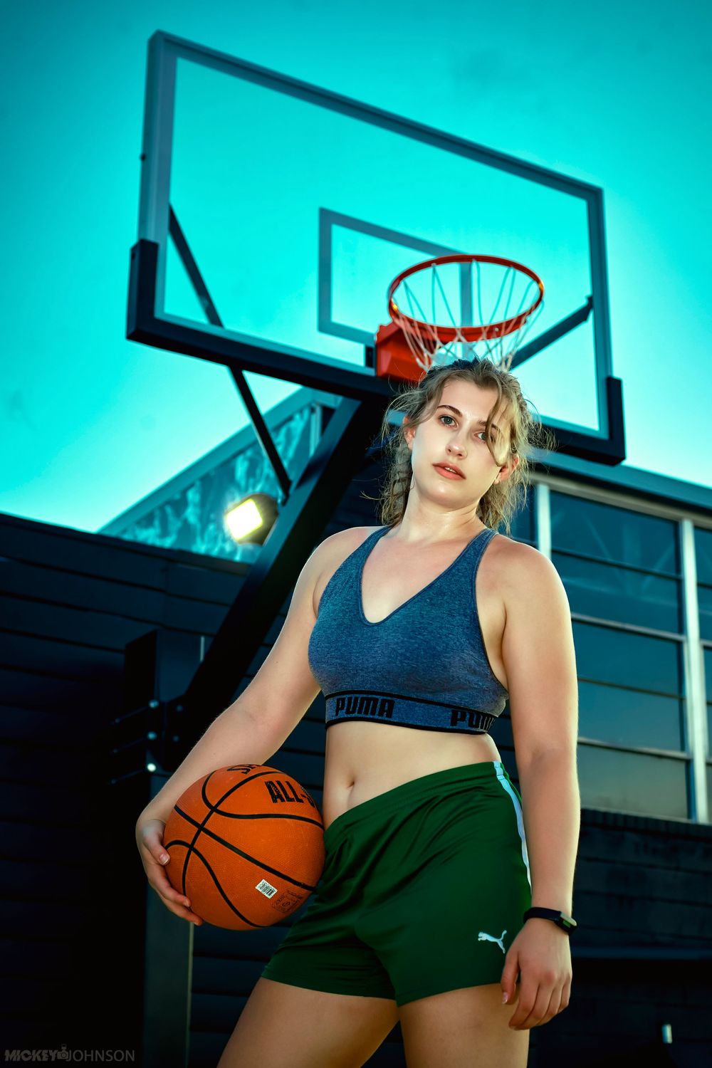 Basketball themed sports portrait with teal background and outdoor court setting.