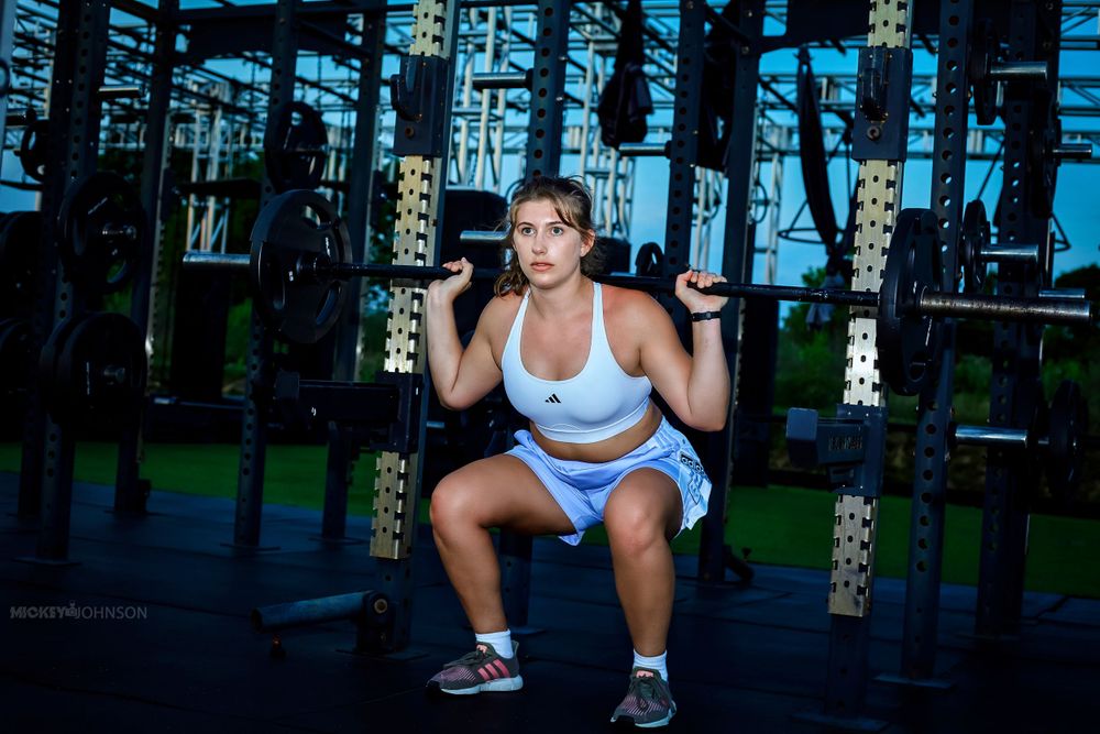 Dynamic fitness photoshoot in outdoor gym setting with exercise equipment.