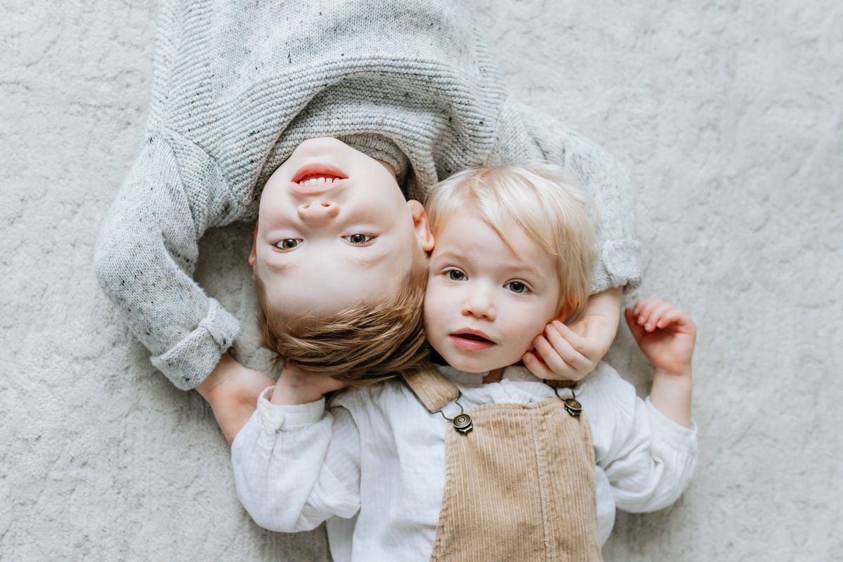 Parents share an intimate moment with their  baby in a bright, white room.