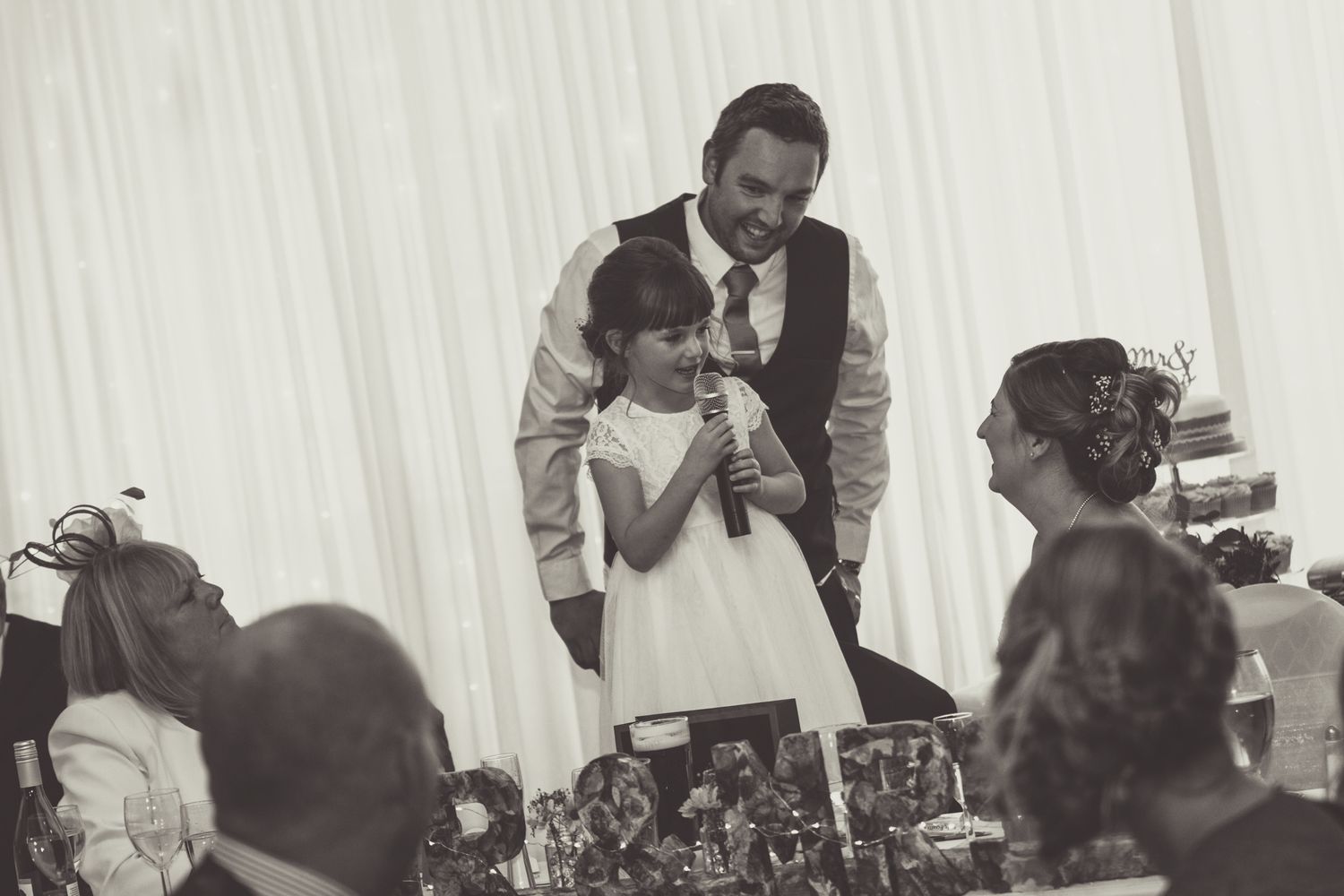 A little girl involedv in the wedding is about to take part in the speeches with a microphone