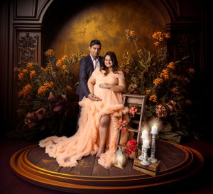 Indoor studio portrait with romantic peach gown against ornate floral backdrop.