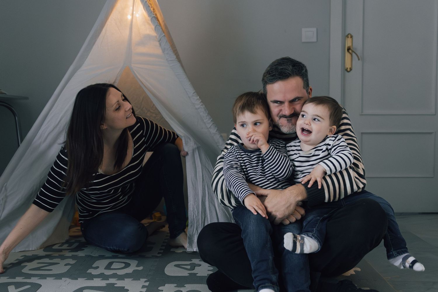 Family sharing tender moment together near white teepee tent in living room.
shooting embarazo
fotógrafa de familia sevilla
shooting recién