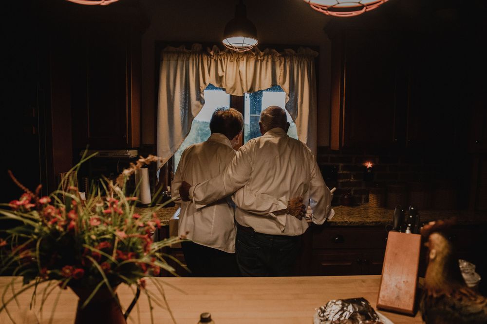 Couple in matching robes standing together at dimly lit venue.