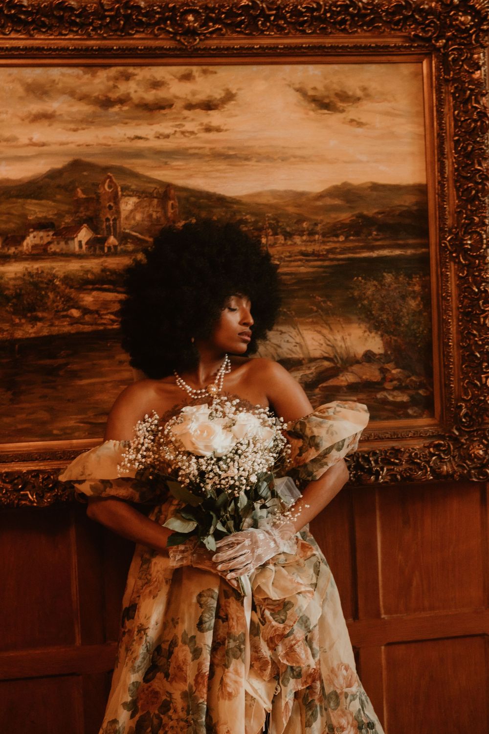 Vintage-toned photo series of a person in a floral dress holding white flowers against ornate framed landscape paintings.