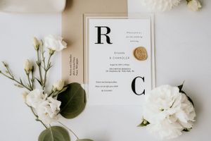 Flatlay wedding details including the wedding invitation and white bud flowers