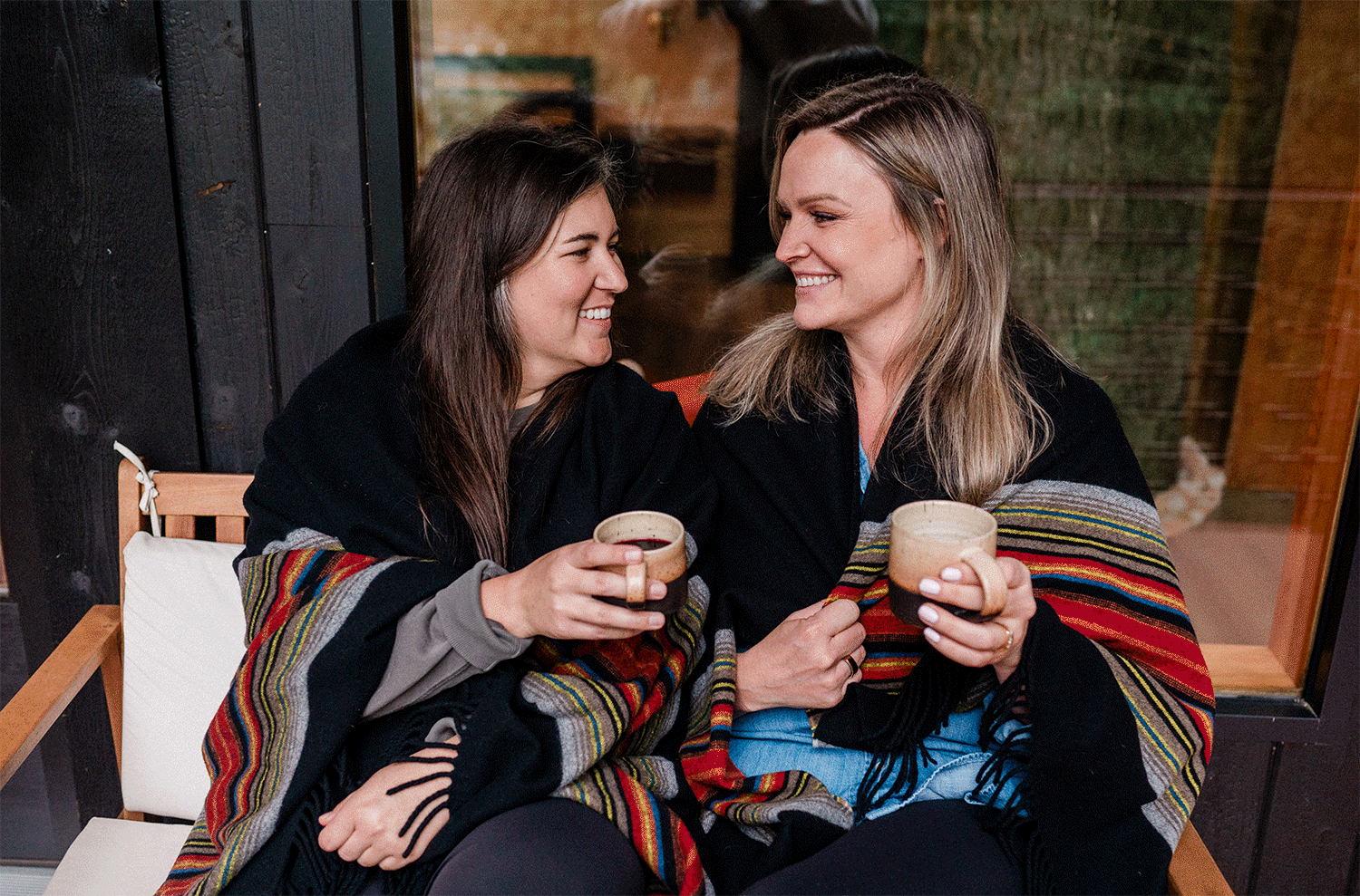 gif of couple toasting and kissing snuggling under blanket. Photo by Pine + Vow.