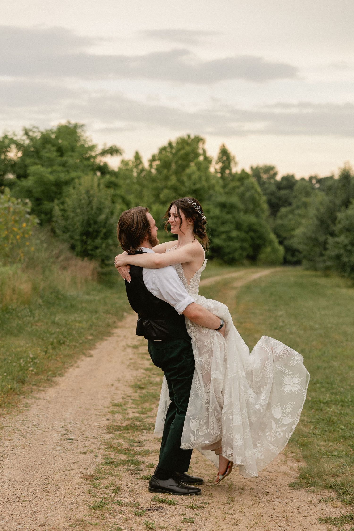 A couple stands together on a rooftop during golden hour.