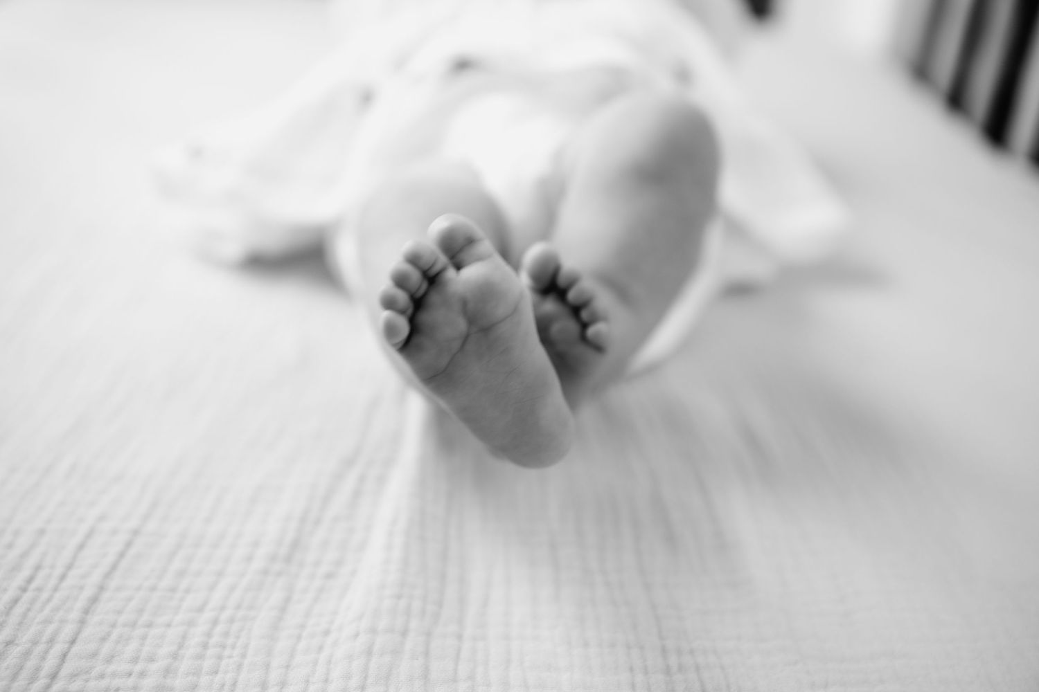 Close up black and white photo of tiny newborn baby feet on white blanket. fresh48. Newport hospital baby girl