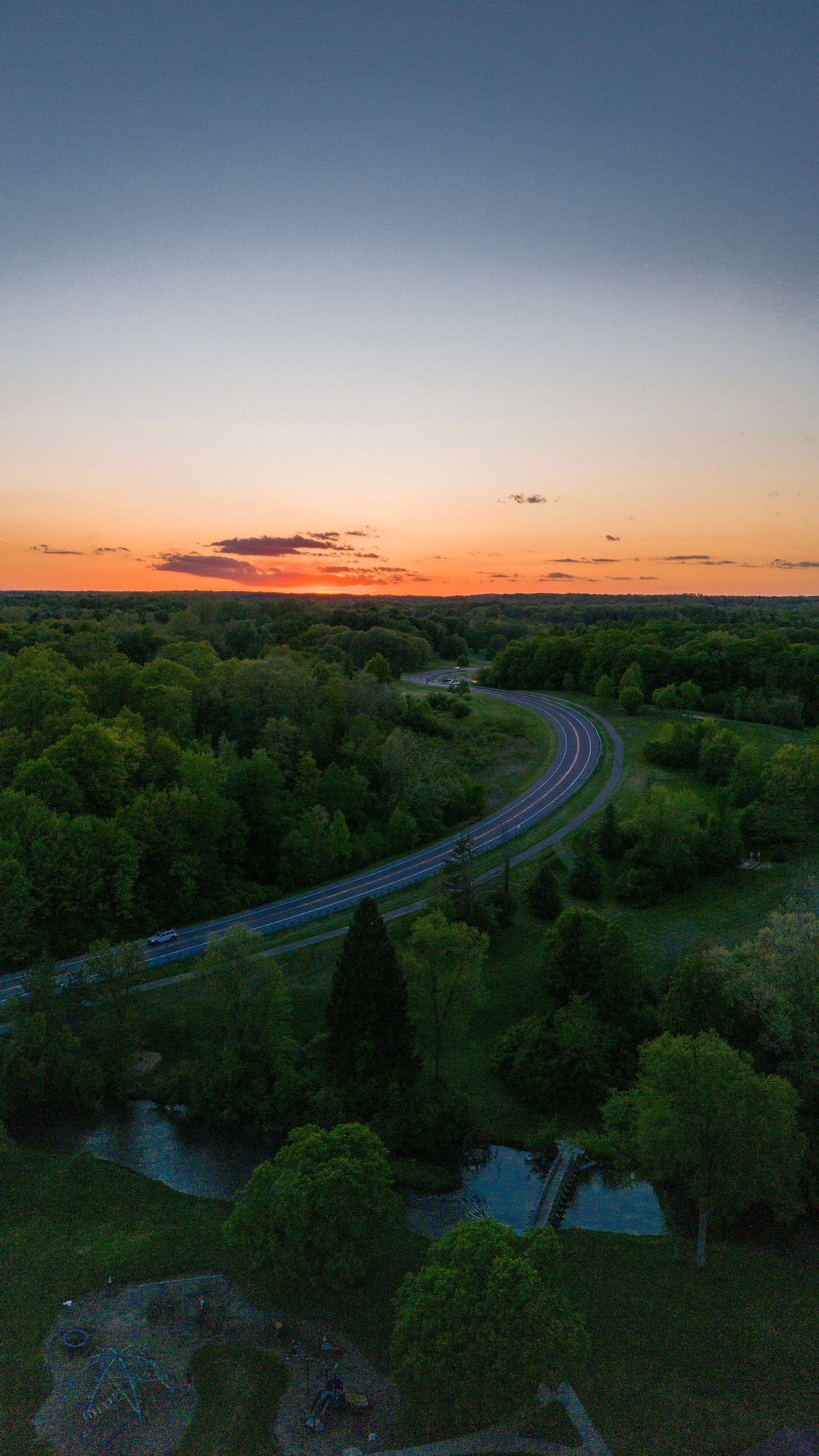 A sunset over a curving road