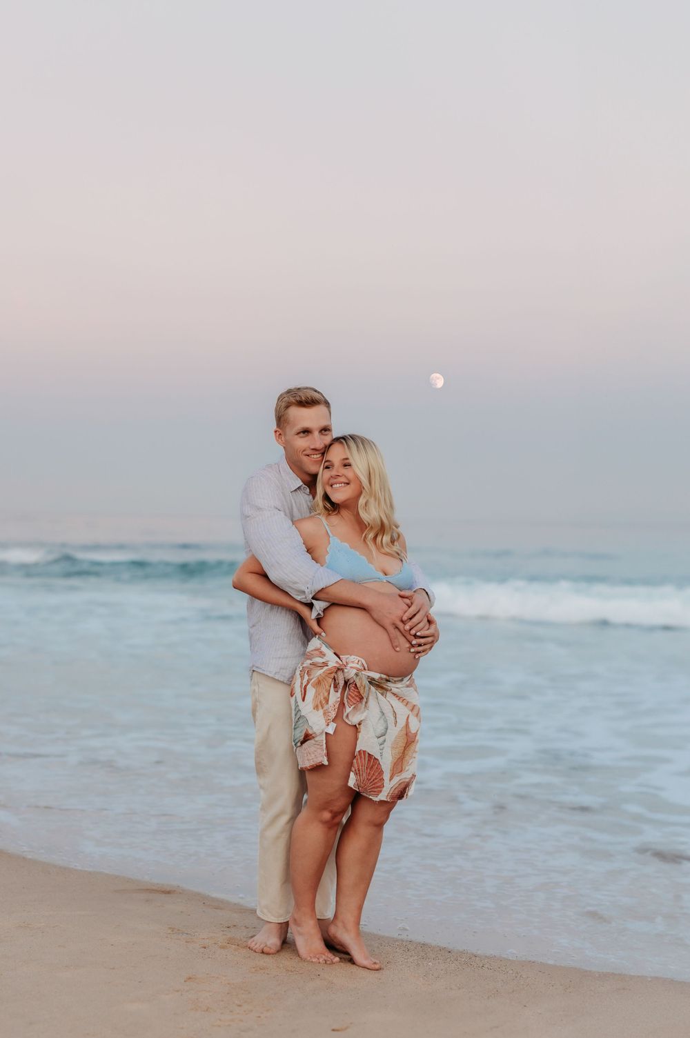 Charlotte Kate Photography. Maternity portrait/session, full moon, mum and dad cuddling at the beach, Sydney, New south wales