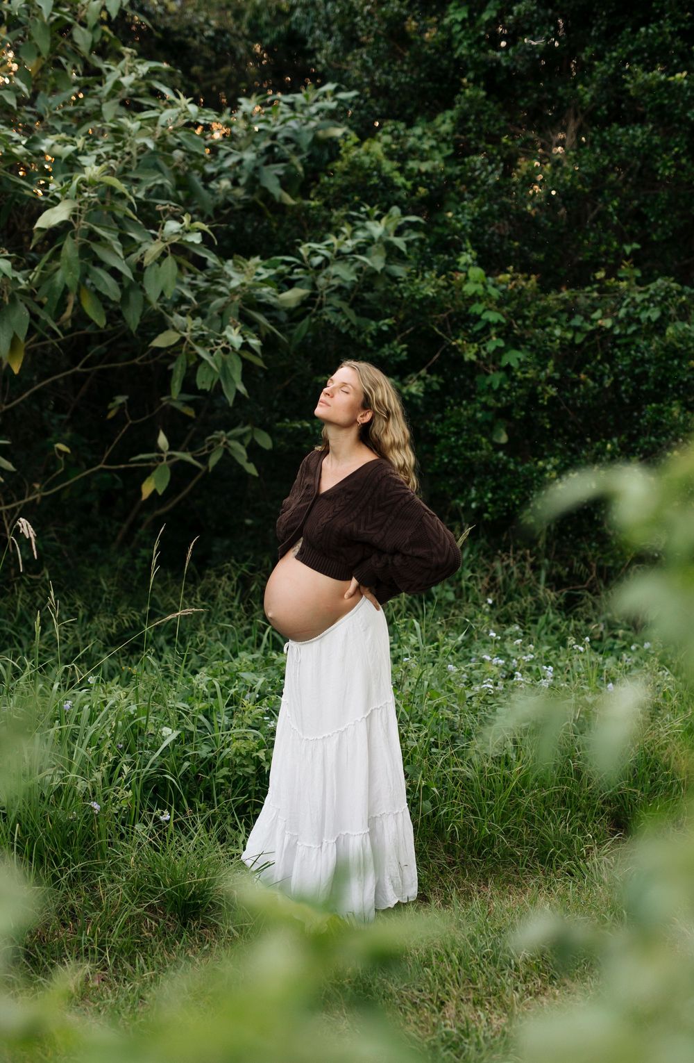 Pregnant woman standing among greenery, Sunshine Coast maternity photography