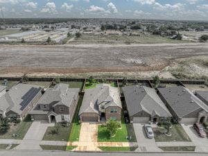 Aerial view of residential neighborhood showing row of houses with neat yards and driveways.