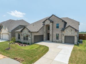 Modern stone facade homes with attached garages and manicured lawns in a new residential development.