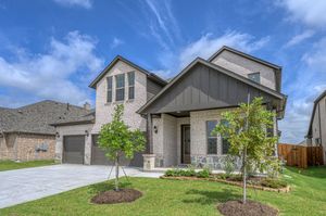 Modern two-story suburban home with gray exterior, attached garage and landscaped front yard under blue skies.