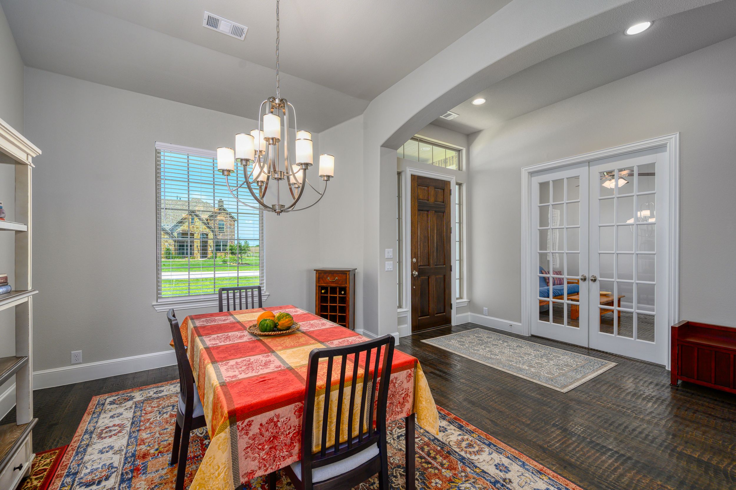 Open concept living area with recessed lighting, gray walls, and dark wood flooring.