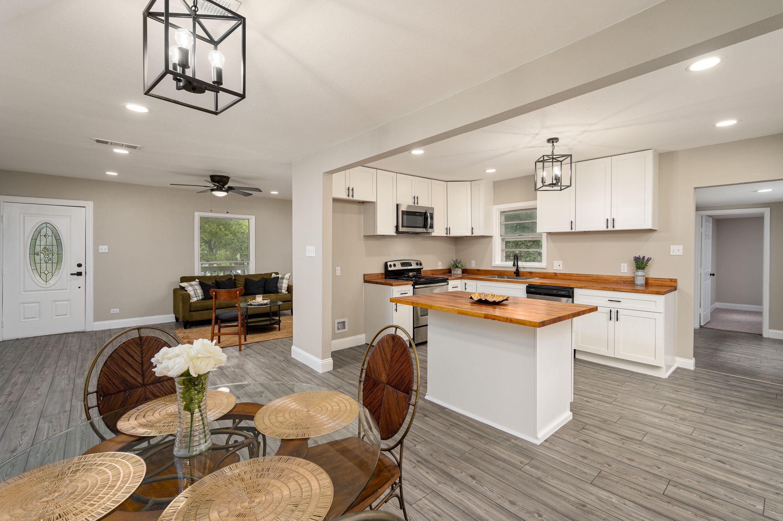 Open concept basement renovation featuring geometric pendant lights and neutral color palette.