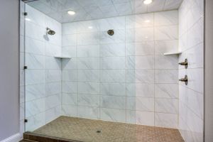 Spacious walk-in shower with dual showerheads and glass enclosure in modern bathroom.