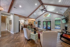 Spacious living room with vaulted ceiling, herringbone floors and modern farmhouse decor.