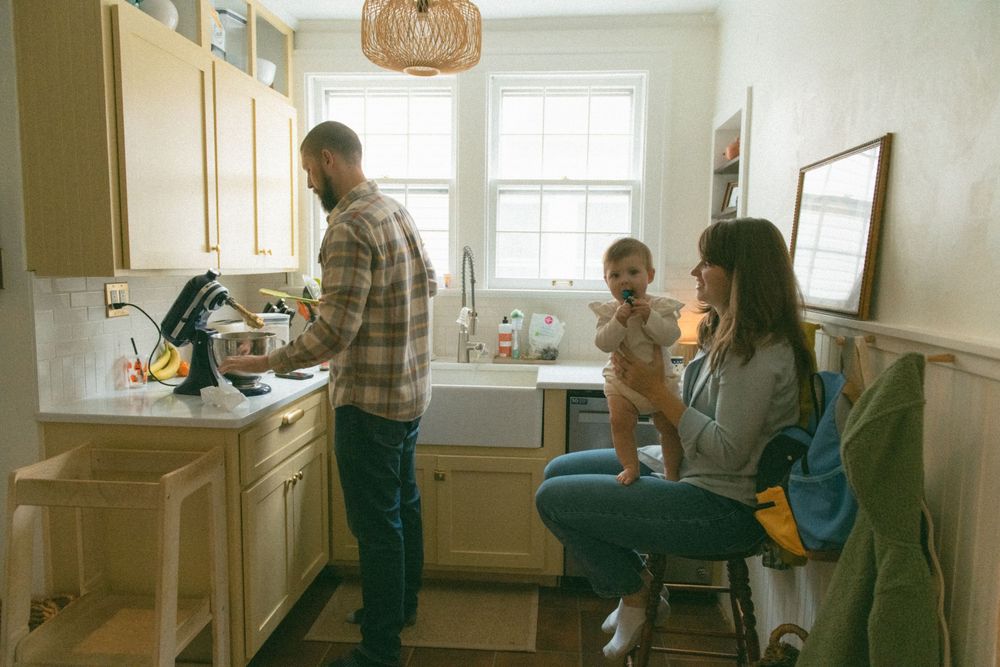 A family spending time together in a cozy kitchen with natural light streaming through the window.