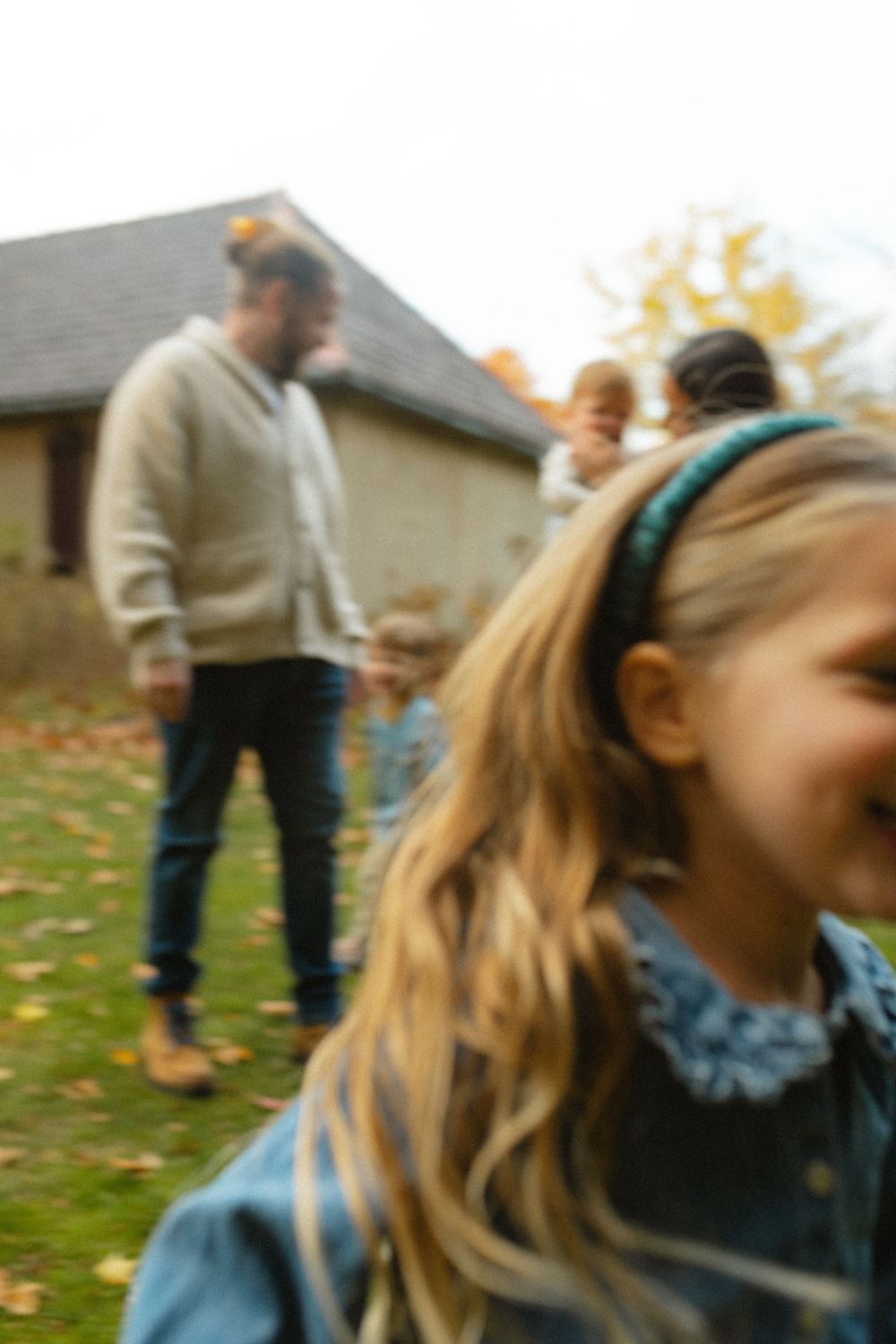 A sequence of motion blur photos showing someone spinning around in a grassy backyard on an autumn day.