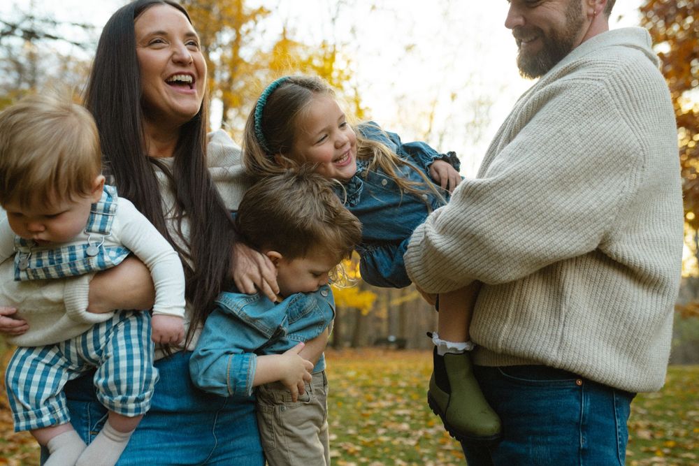 A series of candid family moments captured in autumn showing playful interactions and laughter among loved ones in a park.