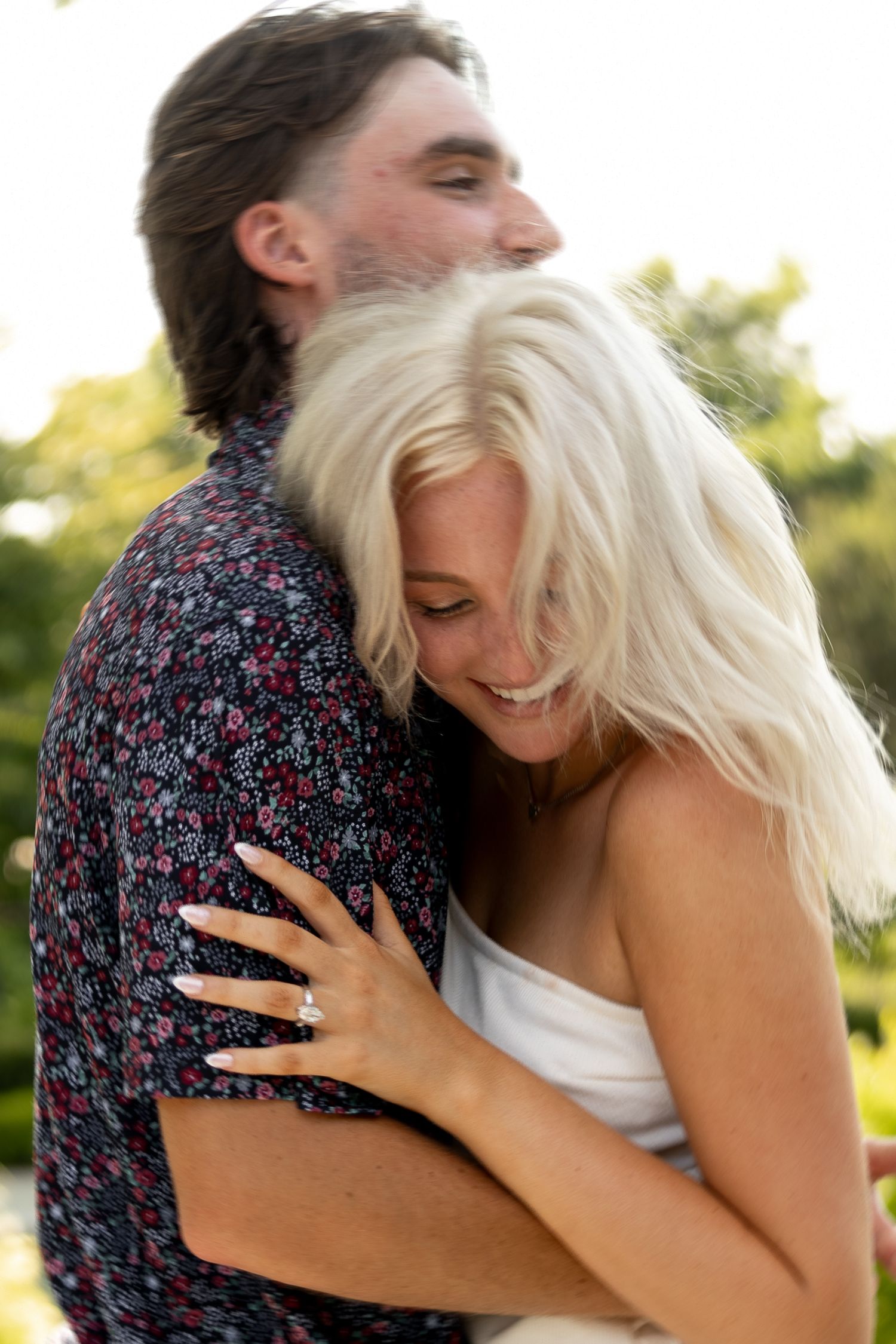 Intimate couple embrace outdoors during golden hour photo session.