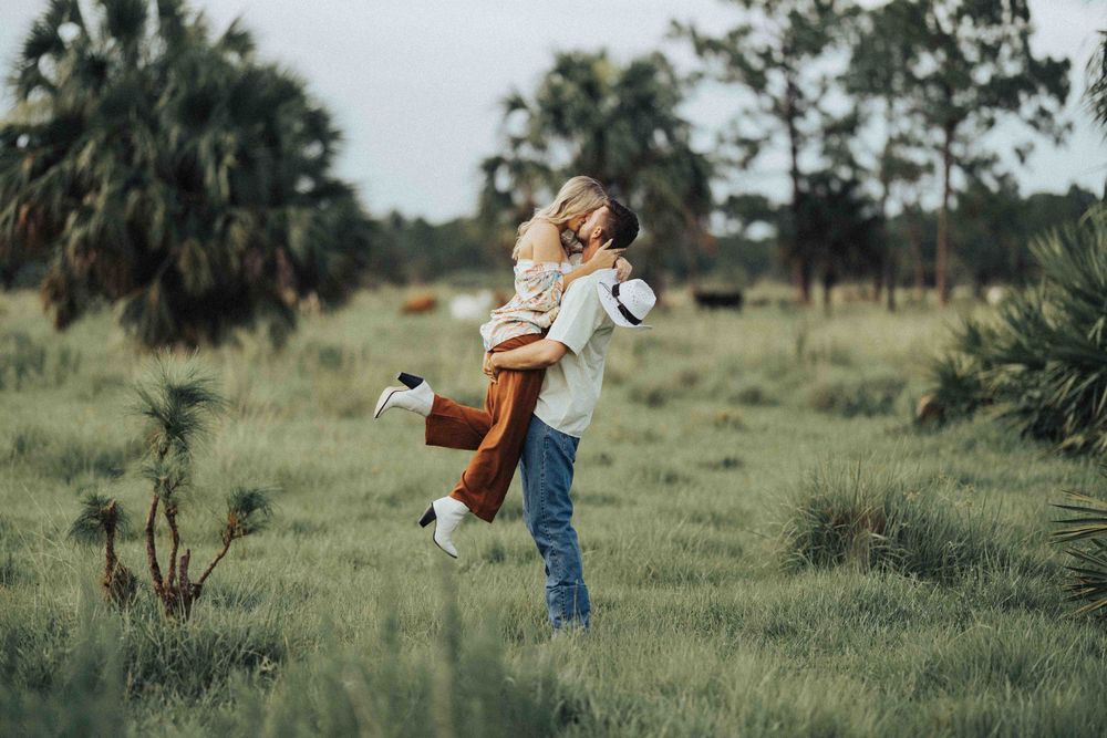 A joyful lift in a grassy field surrounded by palm trees and natural landscape.