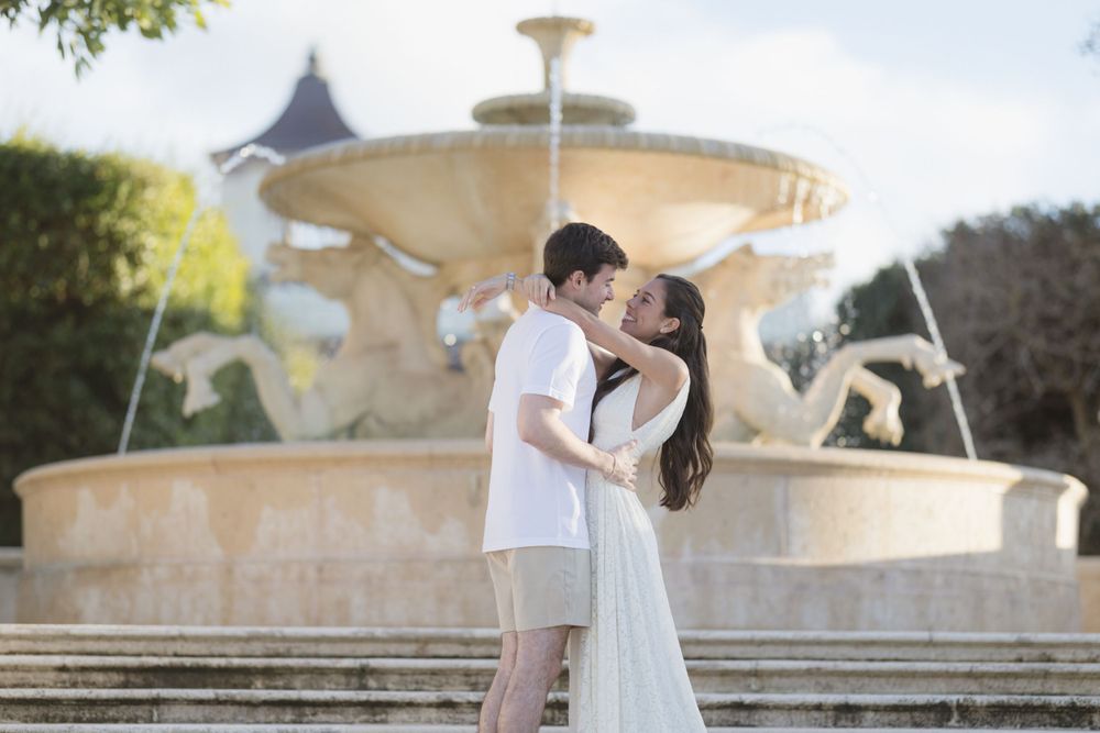 An intimate moment shared by a fountain at golden hour.