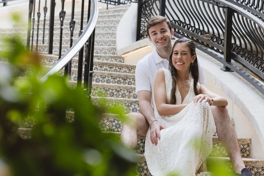 A joyful moment captured on elegant outdoor stairs with decorative railings.