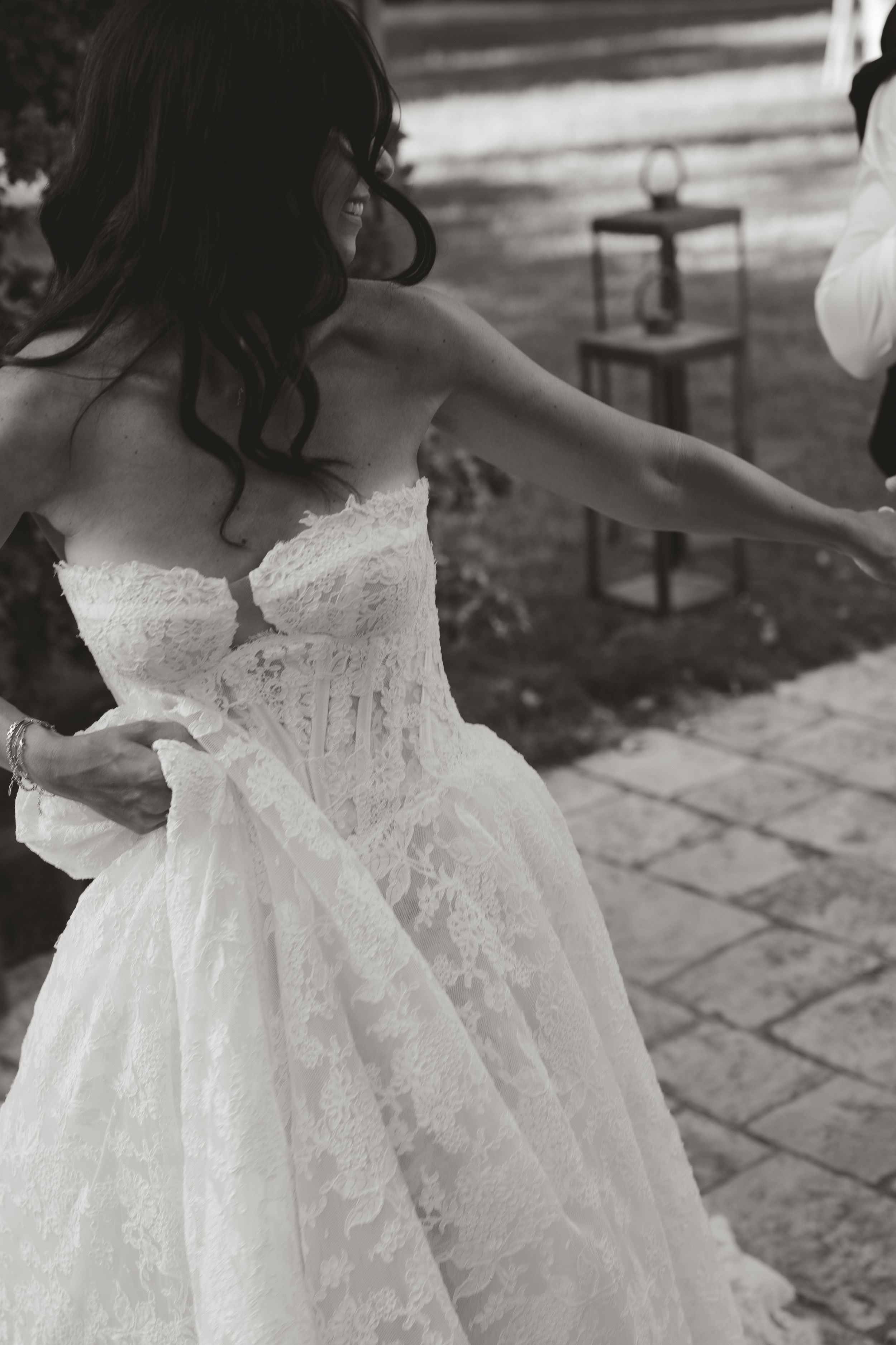 A vintage black and white photo shows the detailed lace and fabric of an elegant white wedding dress bodice.