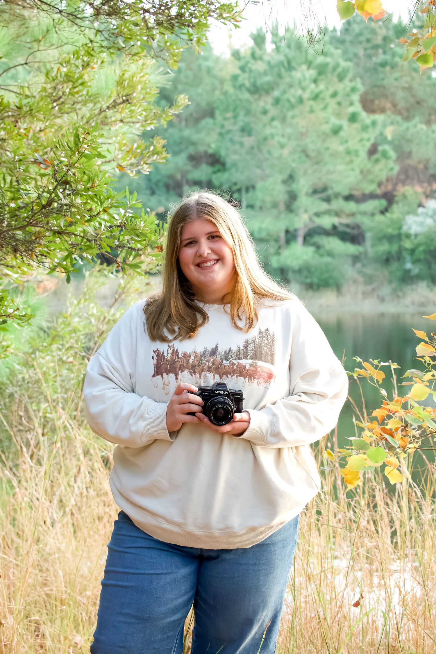 Casual outdoor photography session by a serene lake with autumn foliage.