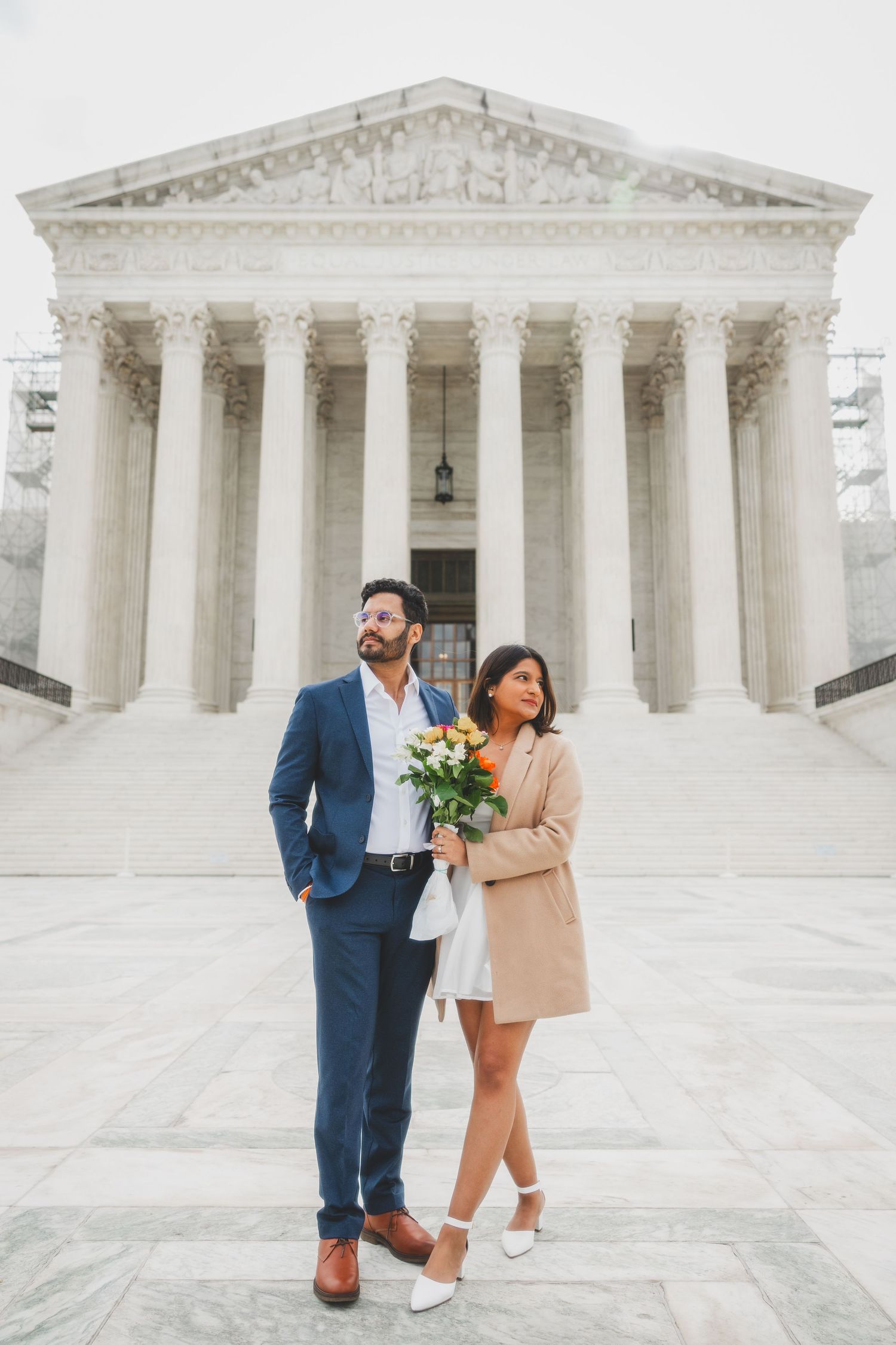 Engaged couple posing in front of the US Supreme Court