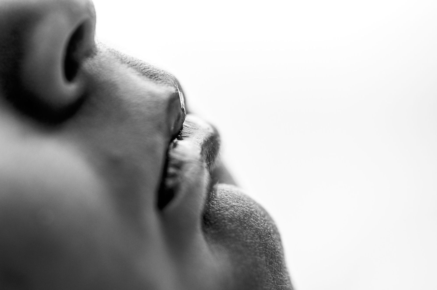 Close-up black and white photo showing details of a person's profile with focus on mouth and lips.