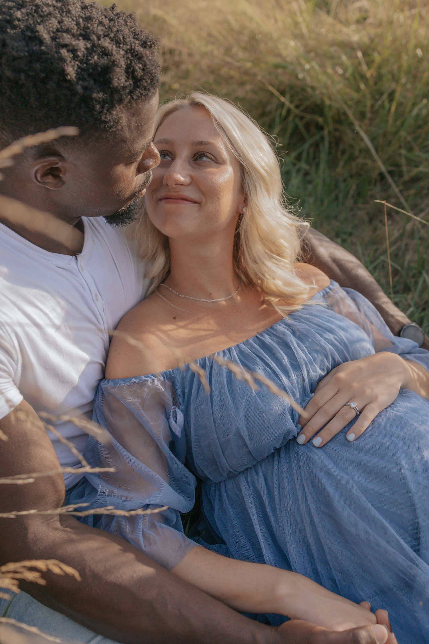 An intimate maternity portrait session in a sun-drenched meadow.