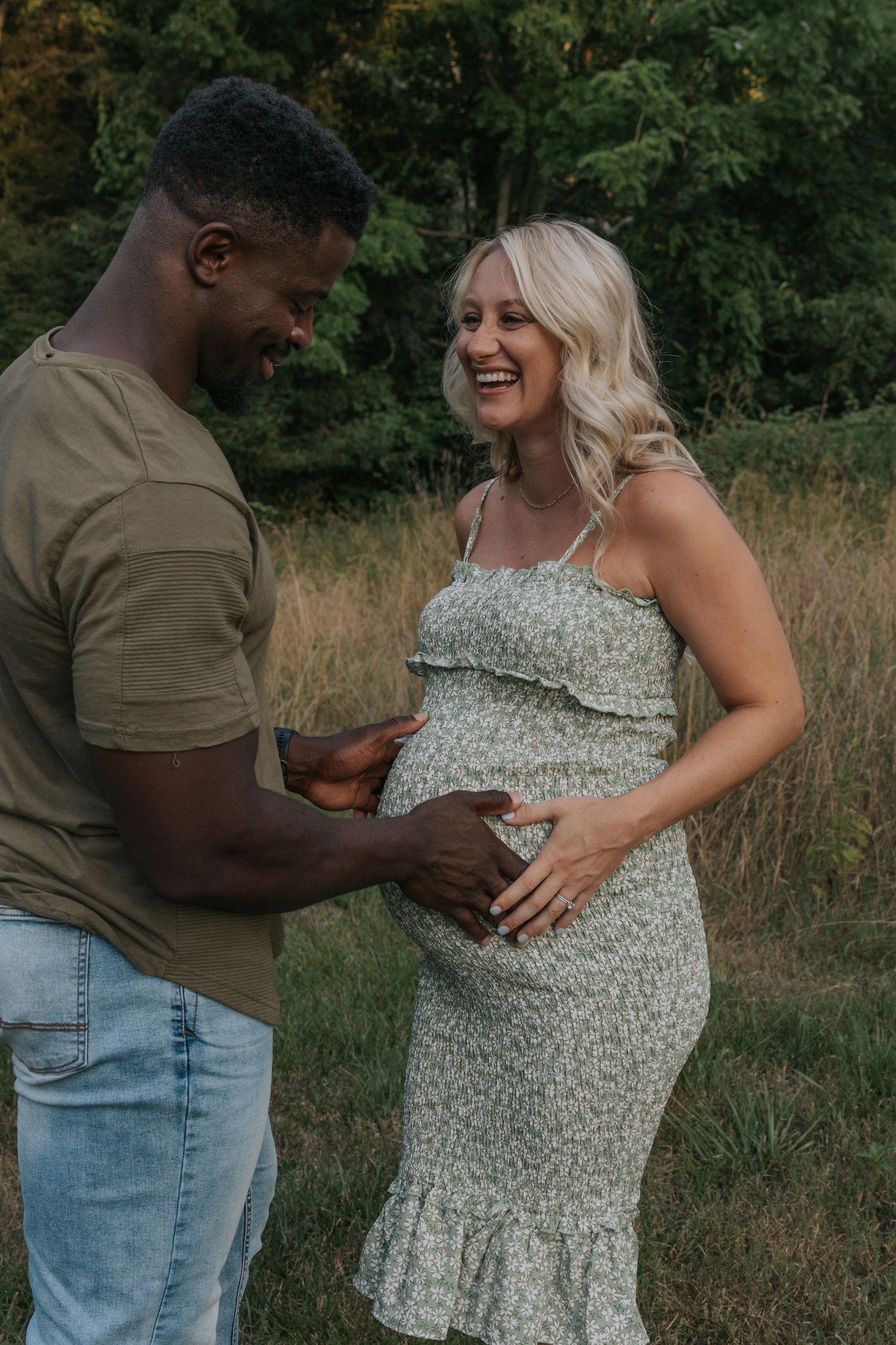 Joyful maternity moment captured outdoors with couple sharing loving interaction.