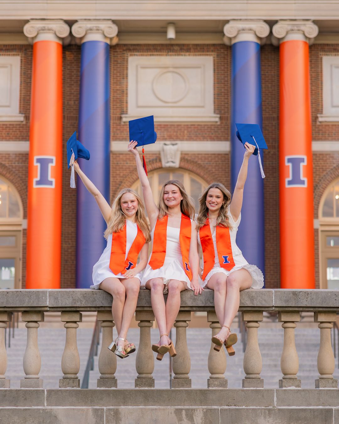 Group of UIUC graduating students sitting together in front of Foellinger