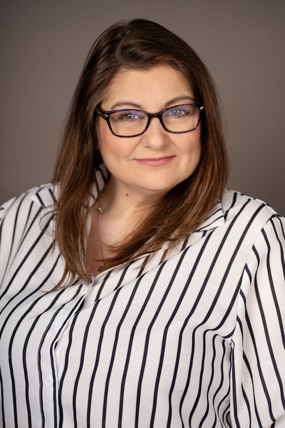 Professional studio portraits in black and white striped top against gray background.