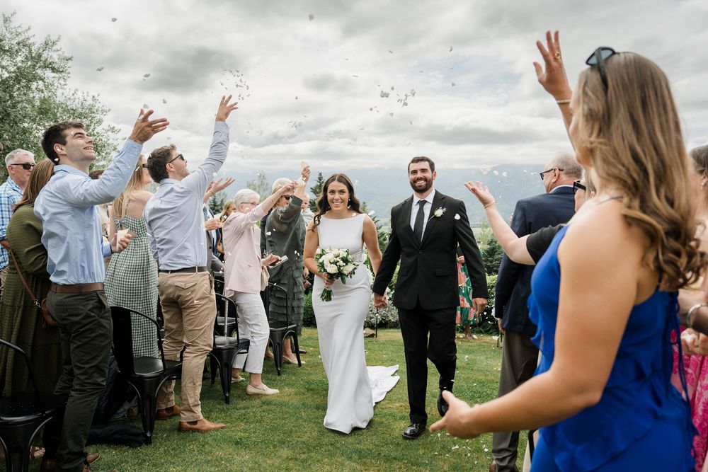 Wedding couple just married walking down the isle with flower petals being thrown on them
