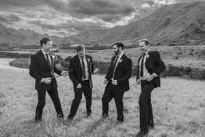 Groomsmen playing air guitar in a paddock around Hanmer Springs