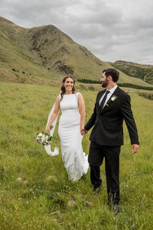 Wedding couple walking and laughing together in a paddock