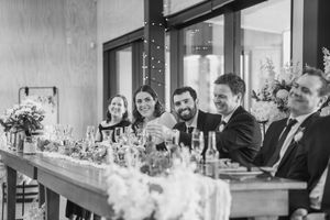 Bridal party laughing during speeches at a wedding