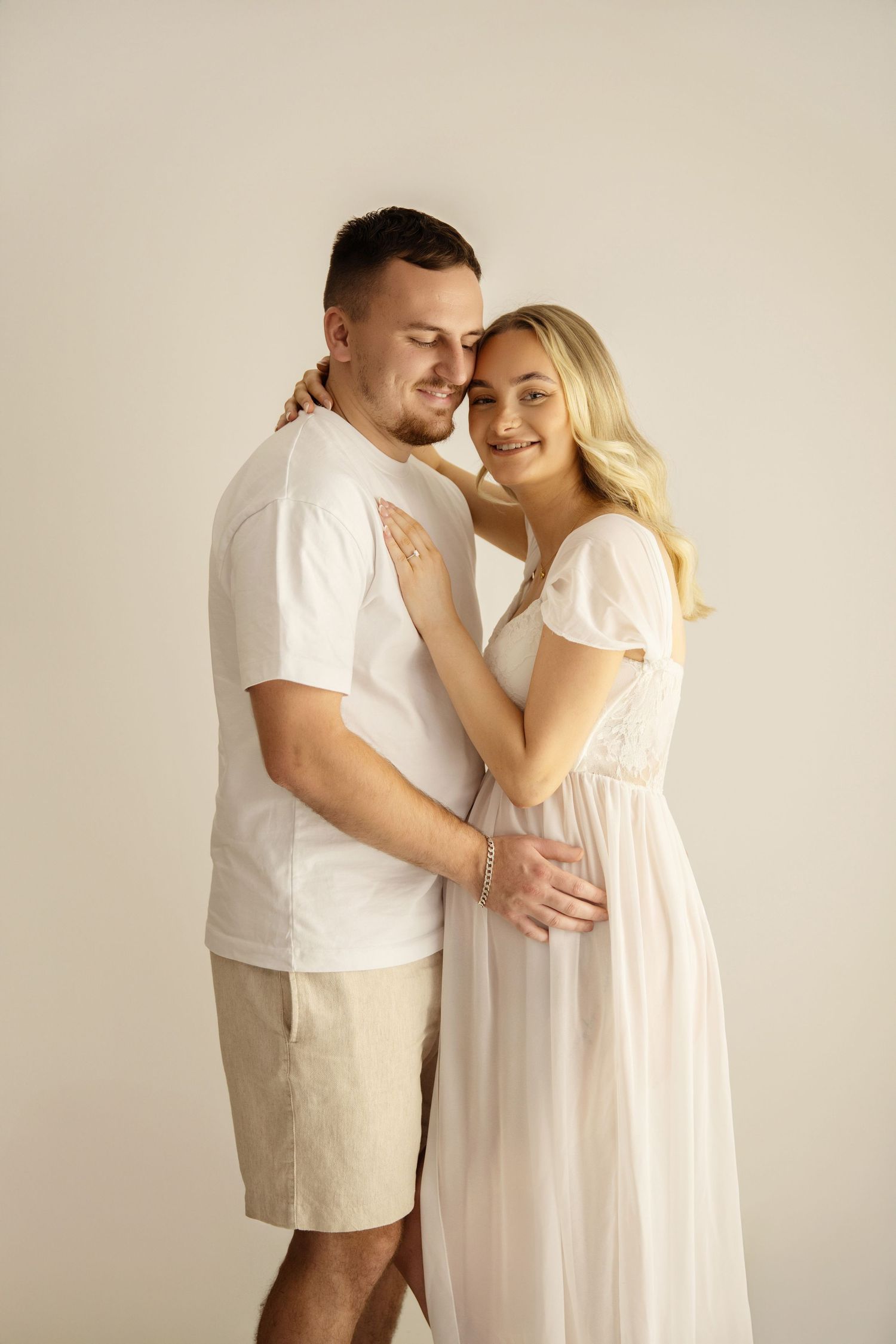 Image of expectant parents cuddling & smiling with Shelly Loxton Photography