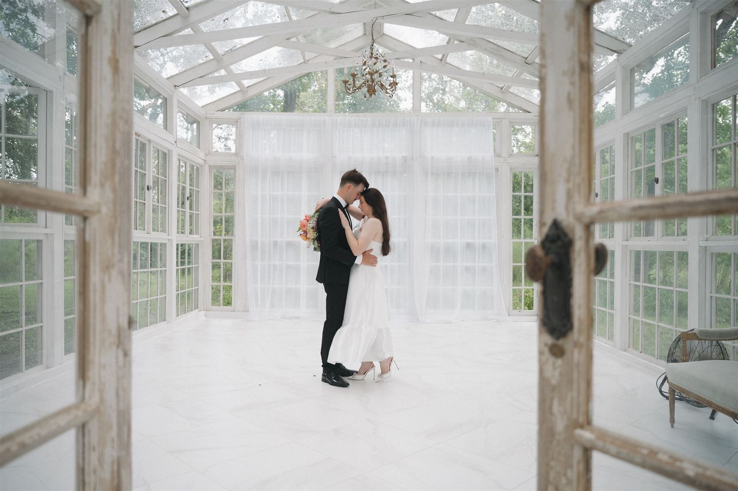 Bride and groom dancing in the glass chapel at The Oak Atelier wedding venue.