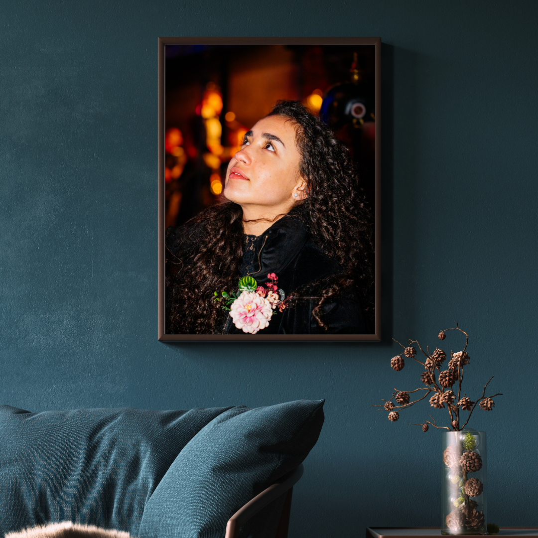 Portrait photo print displayed above a dark couch in a contemporary, dark-themed living room. woman dressed classy at Vastelaovend in Venlo