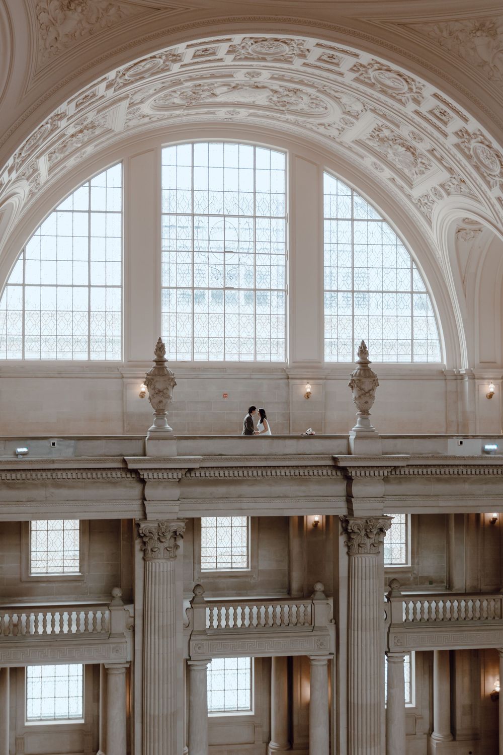 Elegant interior architecture with a large arched window and ornate white details.