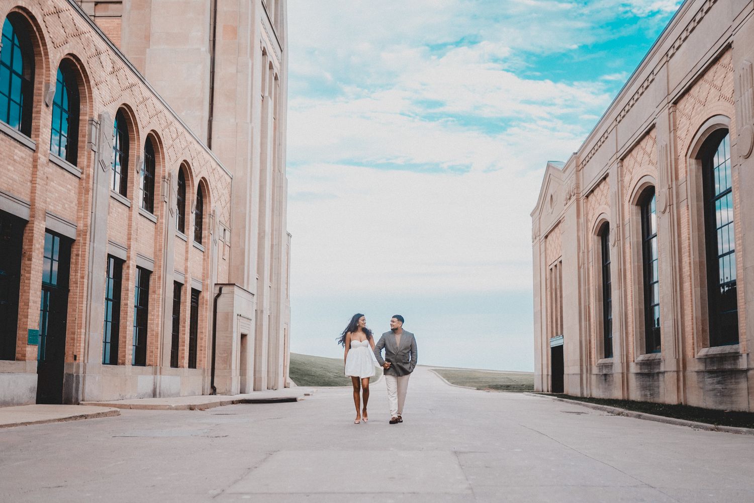 A couple walking together between two classical buildings with arched windows. Indian Wedding Photography Toronto GTA