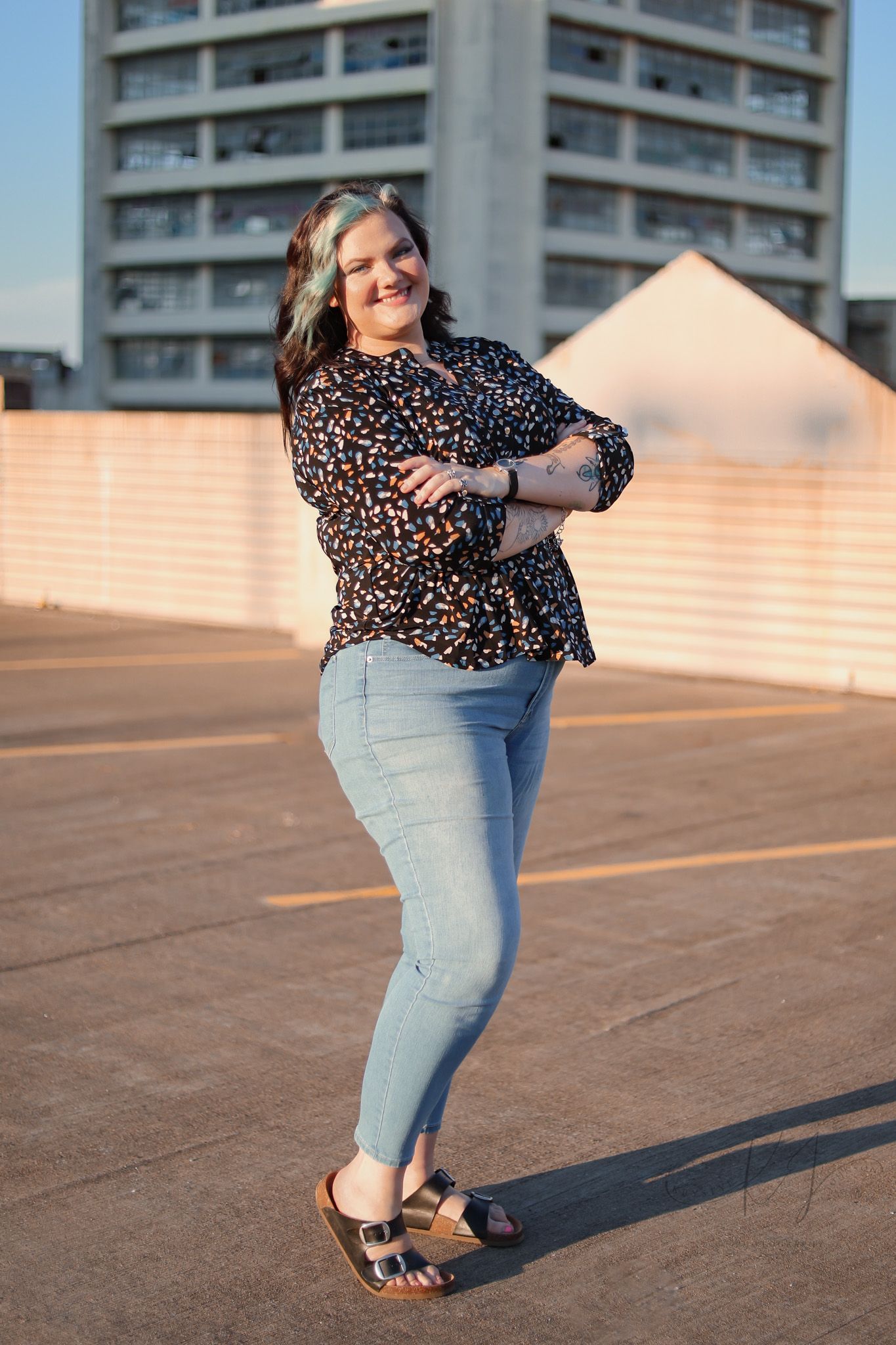 Fashion portrait on a rooftop showing a leopard print top and jeans outfit.